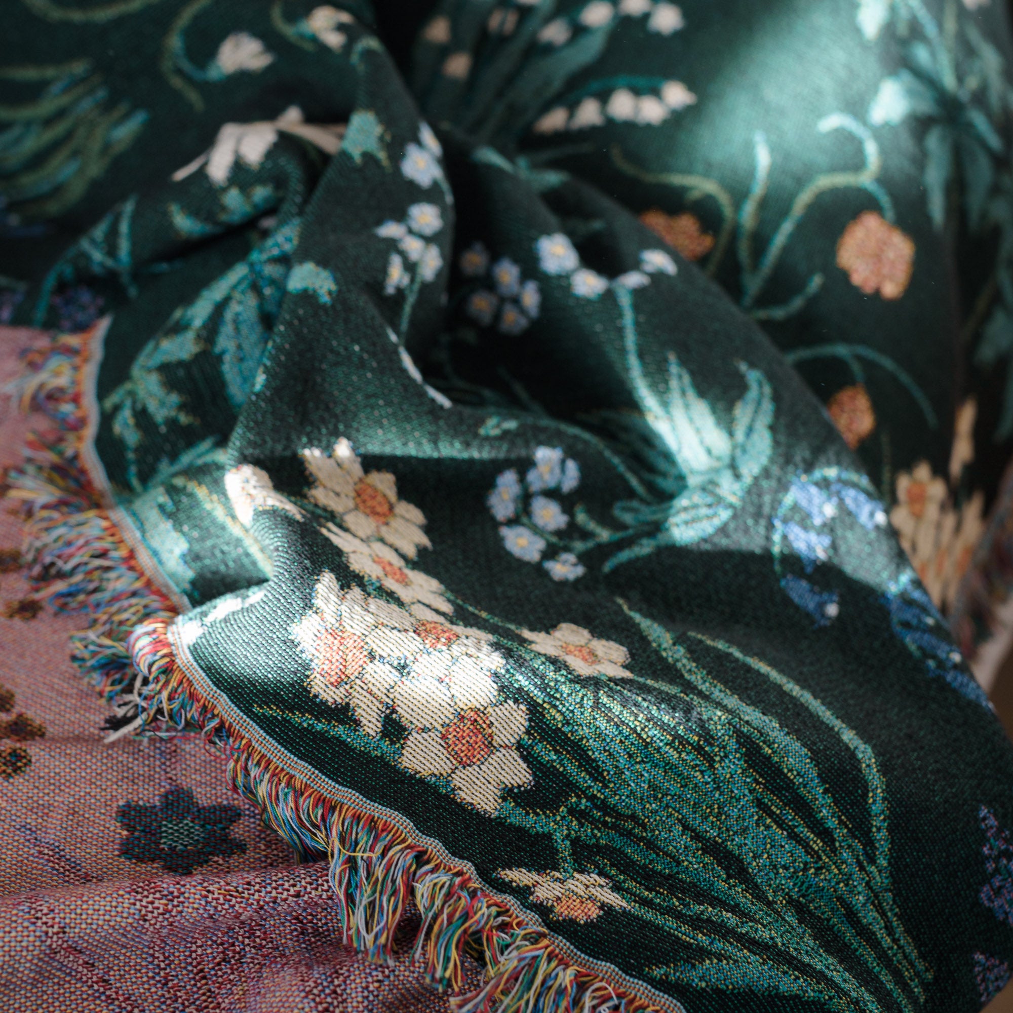 Spring flowers woven blanket in dark green with light coloured daffodils, forget me nots and bluebells