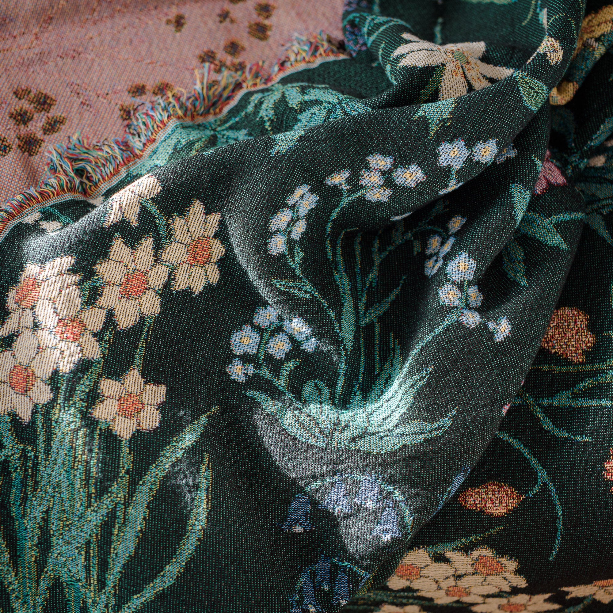 Spring flowers woven blanket in dark green with light coloured daffodils, forget me nots and bluebells