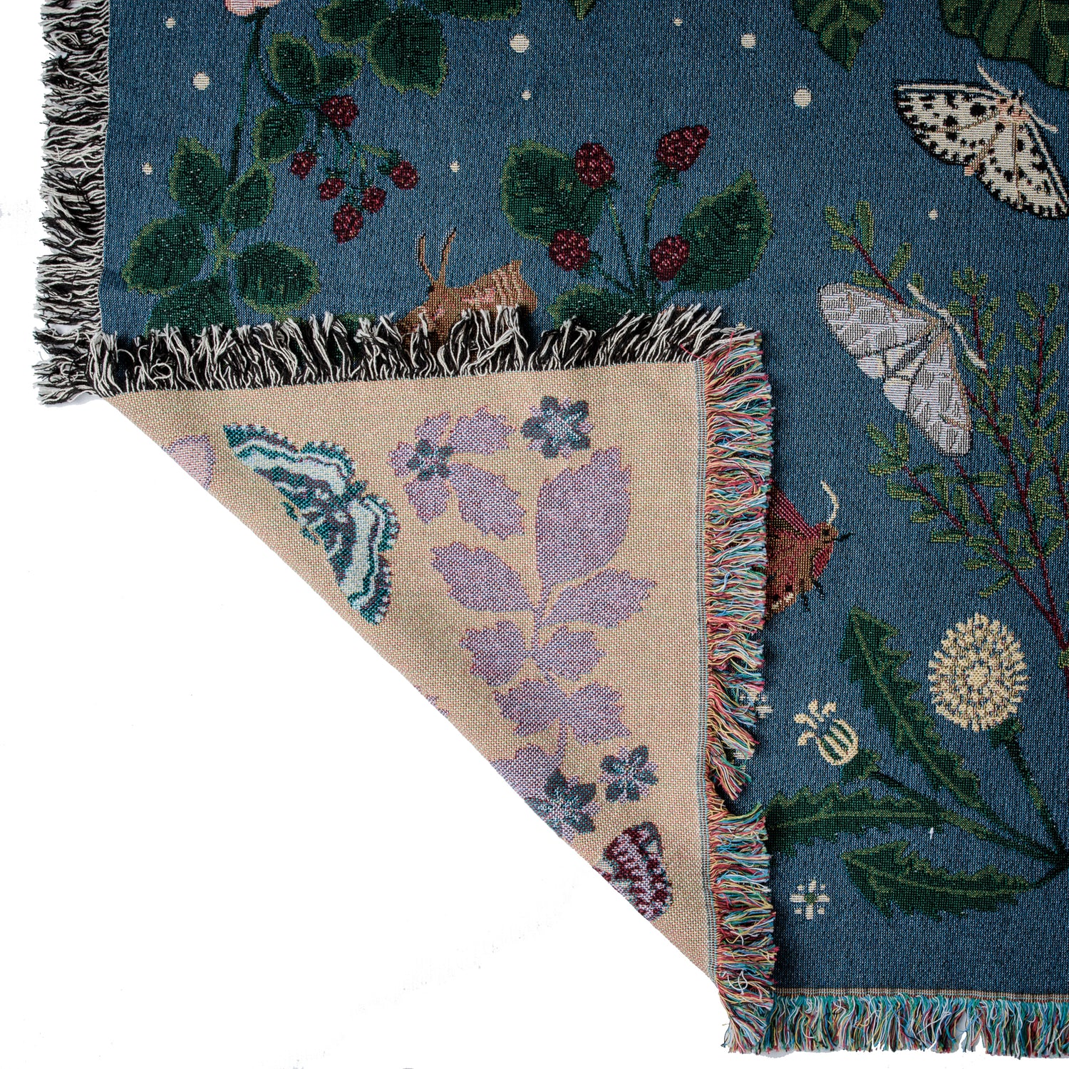 detail of deep blue woven blanket with intricate moth and flower design