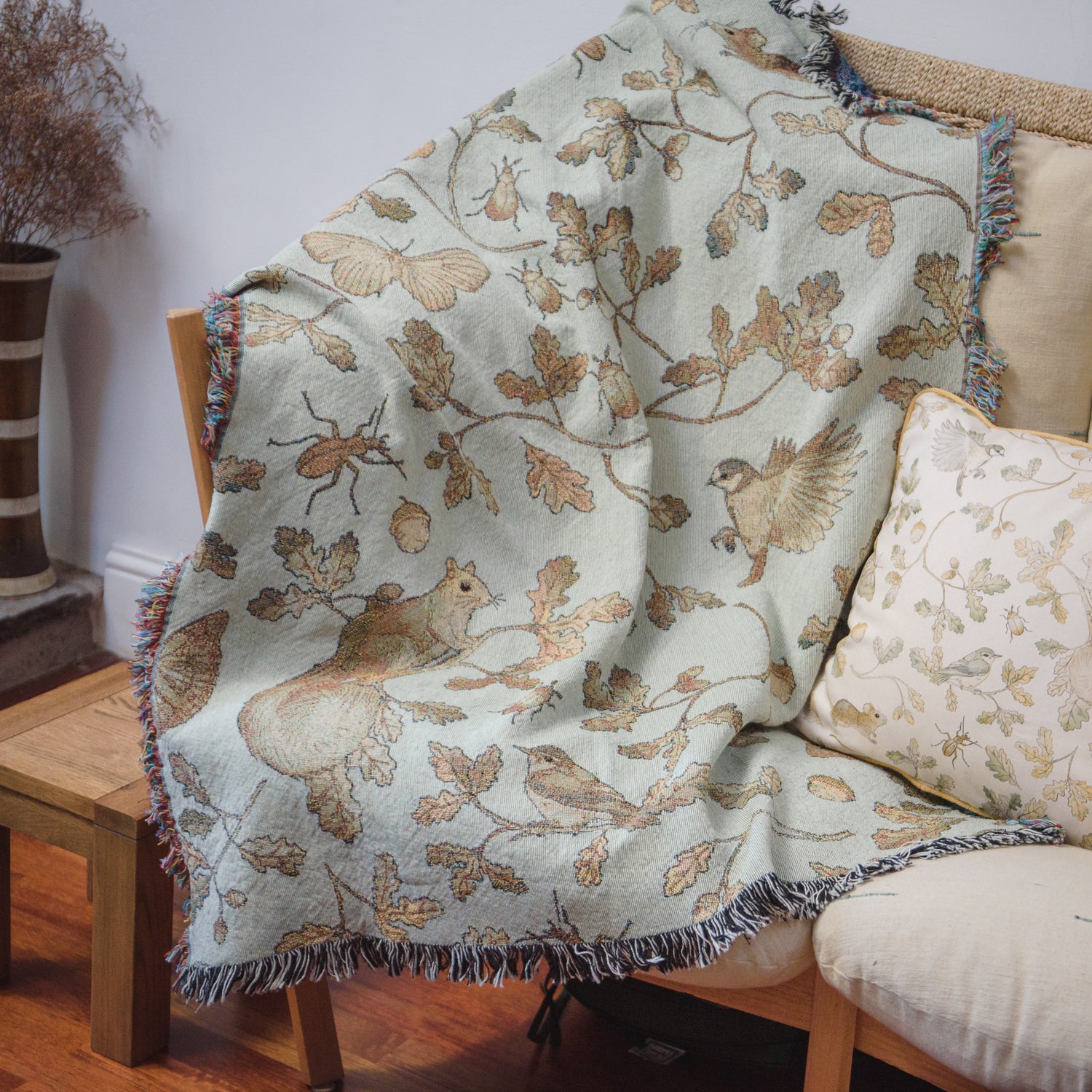 a Wild Oak Wrap Blanket by Arcana on a couch in a living room.