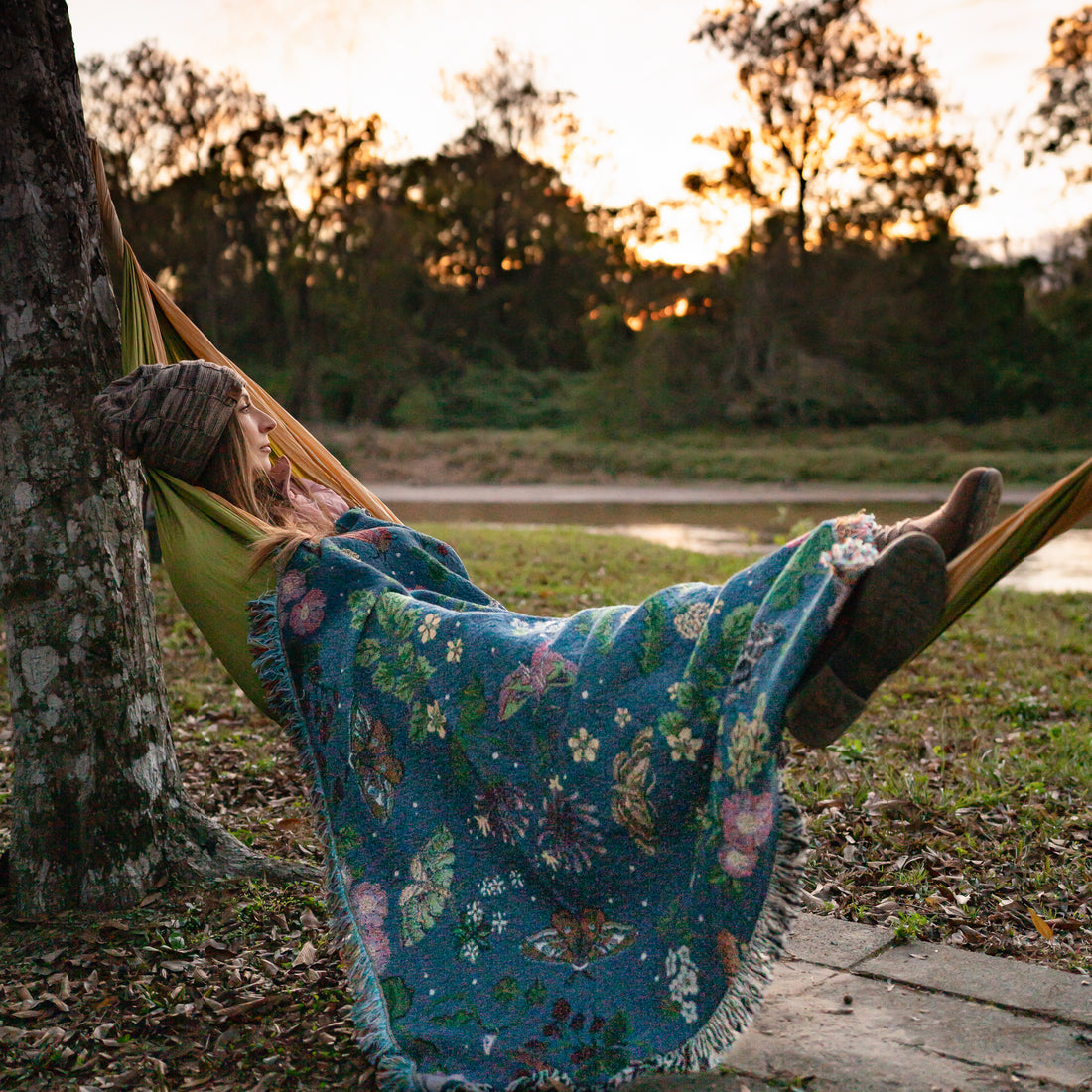 small woven wrap blanket with delicate moth and flower pattern draped over woman in hammock at sunset